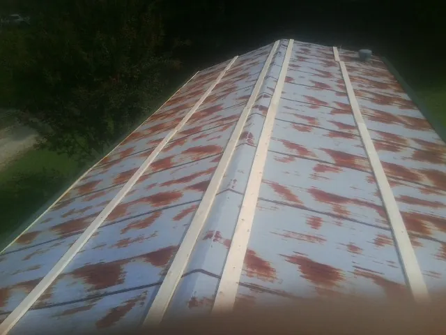 Rusted metal roof panels with new wood purlins before replacement — Storm Damage Roof Repair in Cottontown by Roofing Brothers