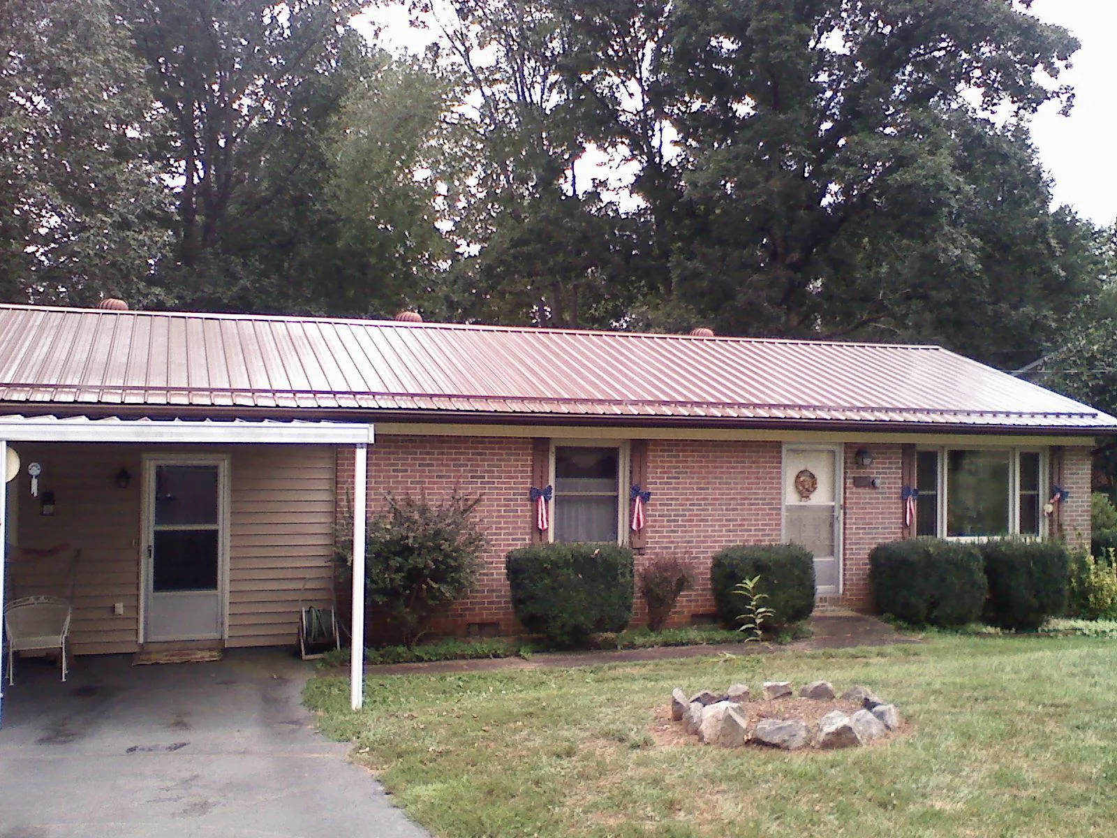 Bronze metal roof and carport on a brick ranch home — Roof Repair work by our crew in Cottontown