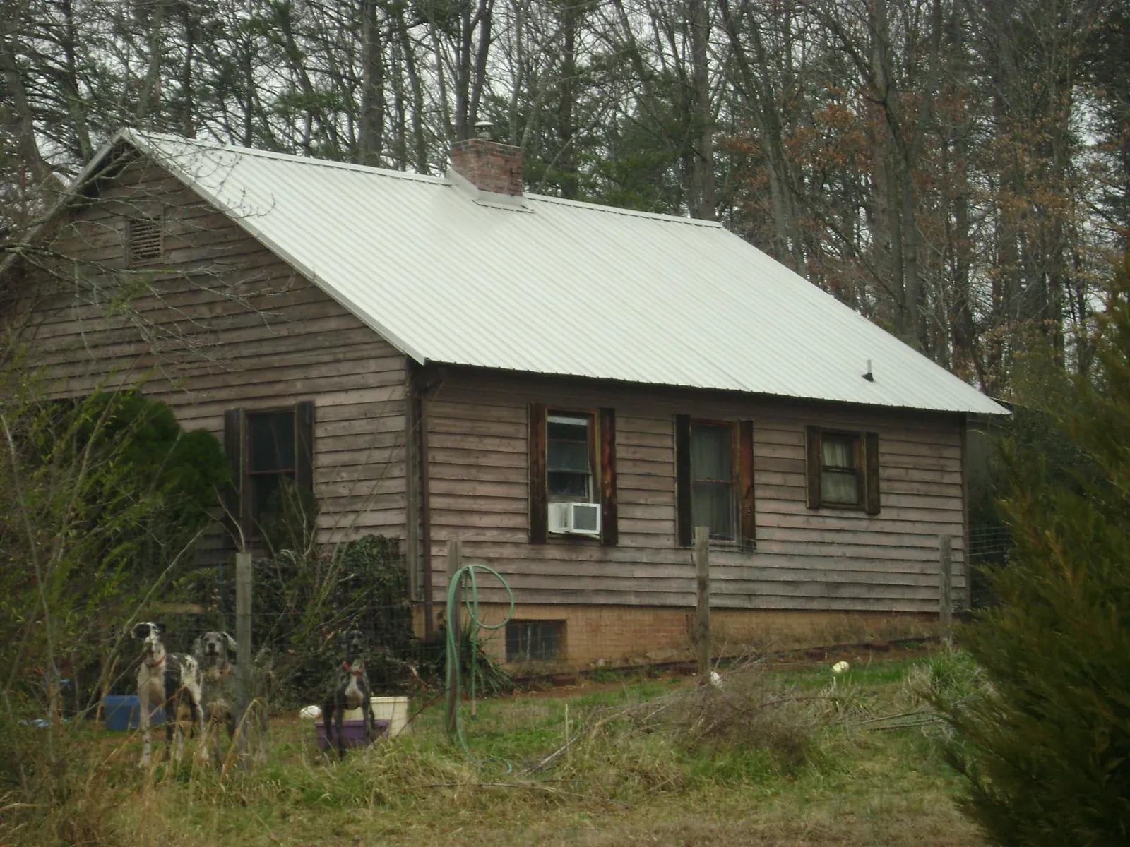 White metal roof on an old wood sided farmhouse, from a Metal Roof Installation job in Cottontown